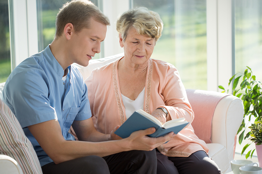 Male senior care assistant caring about elderly woman