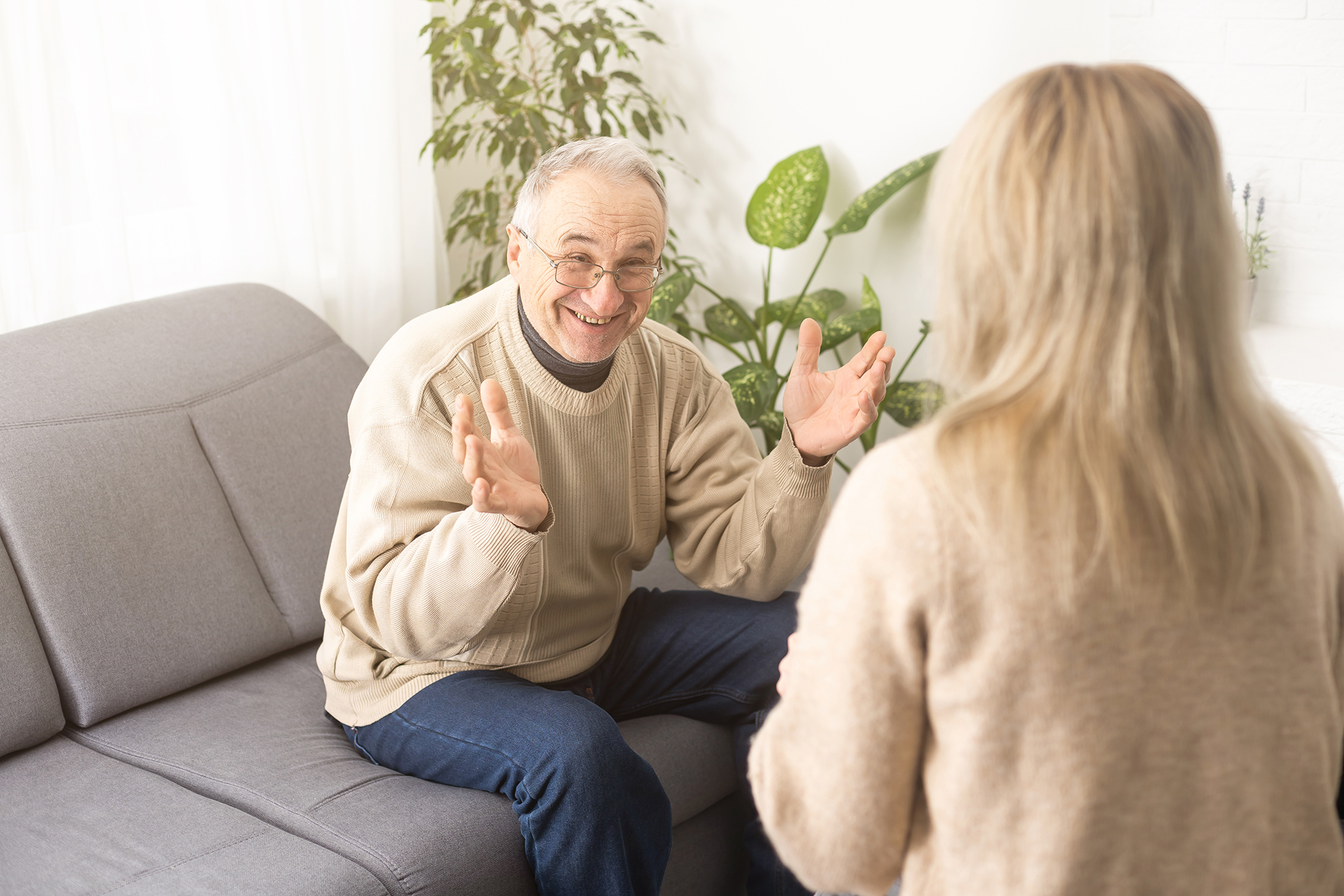 Senior man patient and young woman caregiver medical worker in uniform hold clipboard noting personal information talking listens client telling about health complaints, care support nursing concept