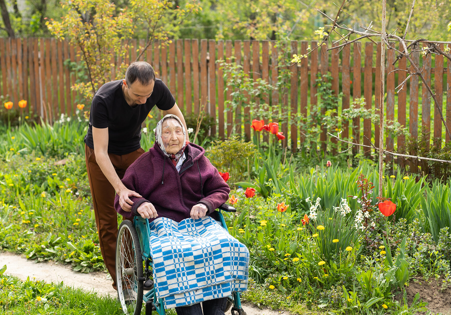 Senior care assistant with very old disabled woman in nursing home